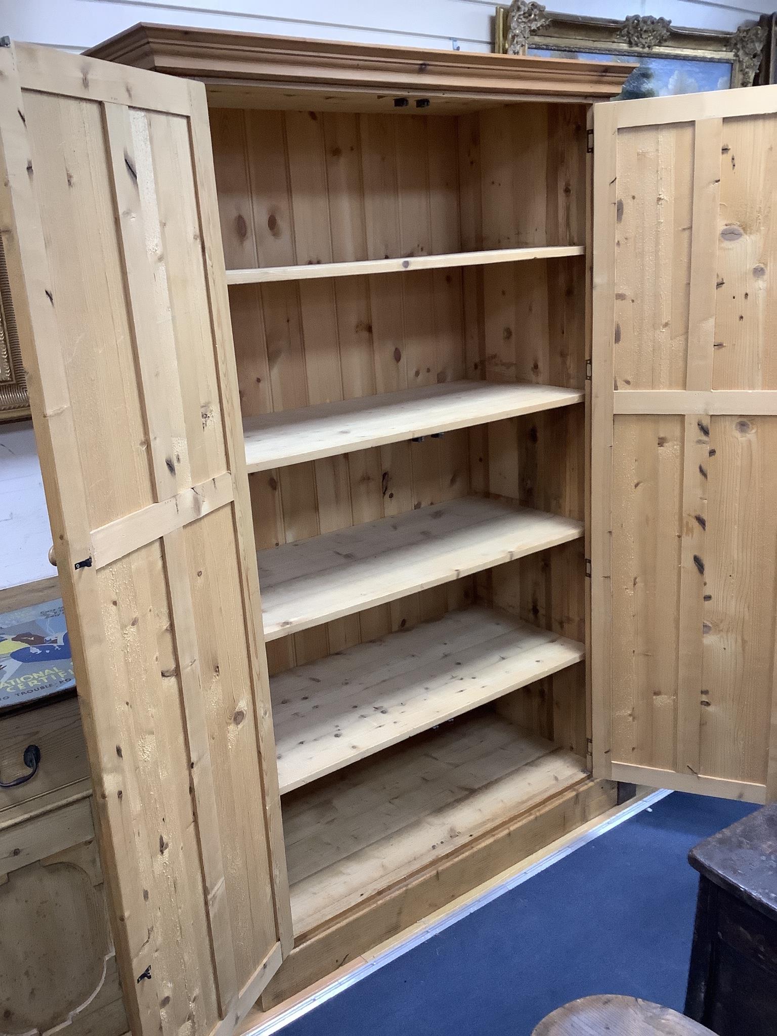 A panelled pine two door wardrobe, length 124cm, depth 59cm, height 197cm